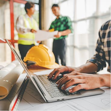 Team reviewing construction plans at a desk with blueprints