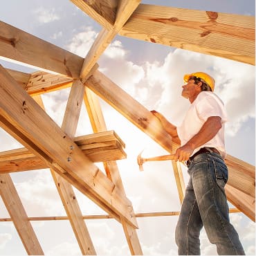 Carpenter inspecting wooden roof framing on site