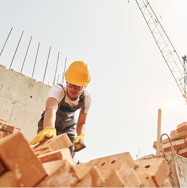 Mason laying bricks at a construction site