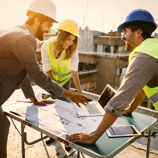 Construction team reviewing printed project plans together on site