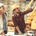 Construction team reviewing blueprints at a residential job-site workbench