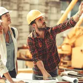 Construction team reviewing blueprints at a residential job-site workbench