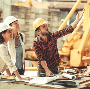 Construction team reviewing blueprints together at an active residential build site