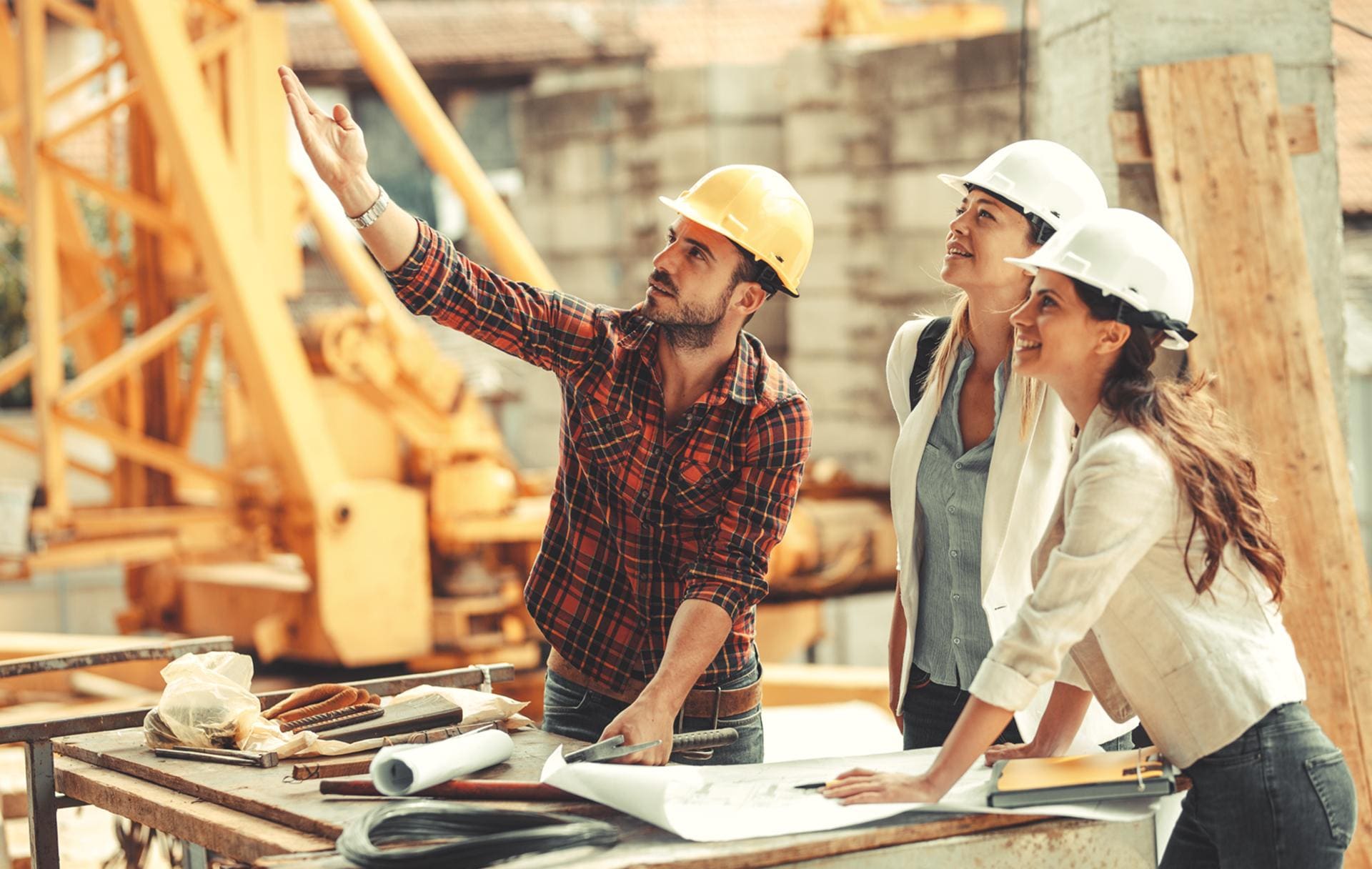 Construction team reviewing blueprints at a residential job-site workbench
